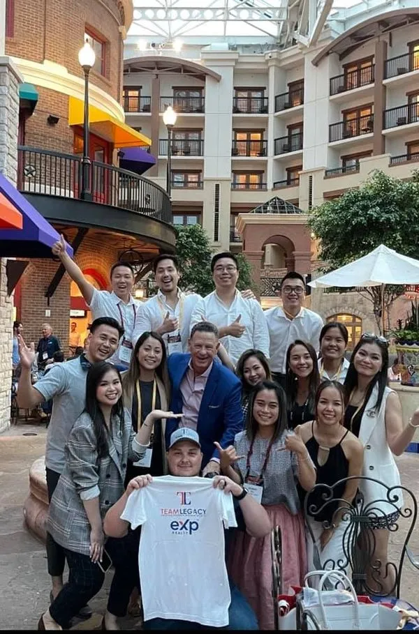 Team Legacy group holding a Team Legacy eXp Realty shirt